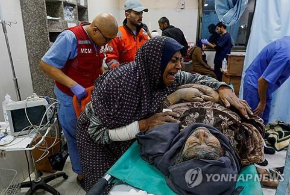 이스라엘 공격으로 부상당한 남편을 부둥켜안고 있는 팔레스타인 여성 (사진 출처: 연합뉴스)