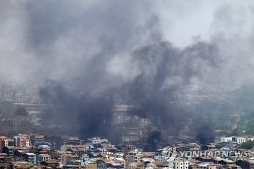 (양곤 AFP=연합뉴스) '미얀마군의 날'인 27일(현지시간) 미얀마 전역에서 군부 쿠데타 규탄 시위가 벌어진 가운데 최대 도시 양곤의 탐웨 지역에서 검은 연기가 솟아오르고 있다.