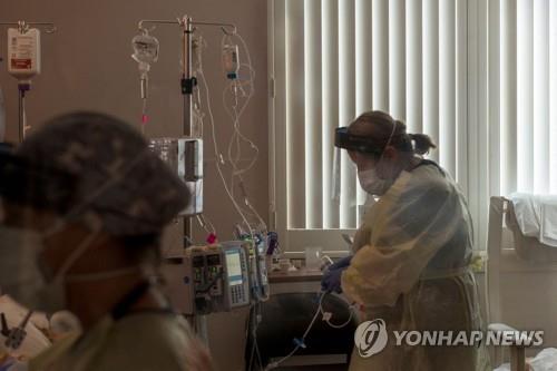지난달 27일 미 캘리포니아 소노라의 어드밴티스트 헬스 병원 중환자실에서 한 간호사가 코로나19 환자의 상태를 살펴보고 있다. 