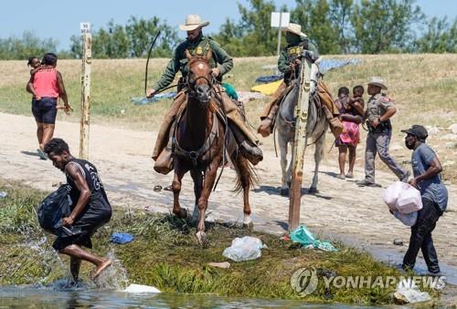 말 고삐를 휘두르는 미 국경순찰대에 쫓기는 아이티 난민들[사진 출처: AFP / 연합뉴스]