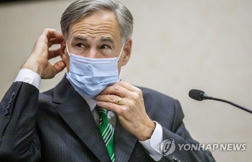 그렉 에봇 텍사스 주지사가 마스크를 고쳐 쓰고 있는 모습. [AP=연합뉴스 자료사진]