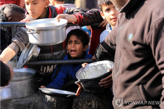 구호식량 배급 기다리는 팔 어린이들 (사진 출처: 연합뉴스)