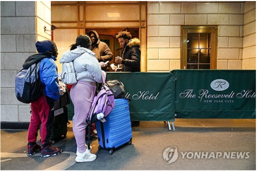 지난 1월 뉴욕 루스벨트 호텔에서 서류 제시하는 이민자 가족 (사진 출처: 연합뉴스)