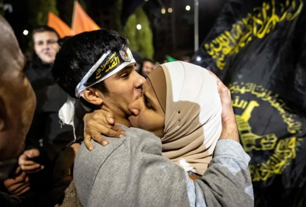 이스라엘 감옥에서 풀려난 팔레스타인 수감자가 28일 요르단강 서안지구에서 가족과 만나 포옹하고 있다.