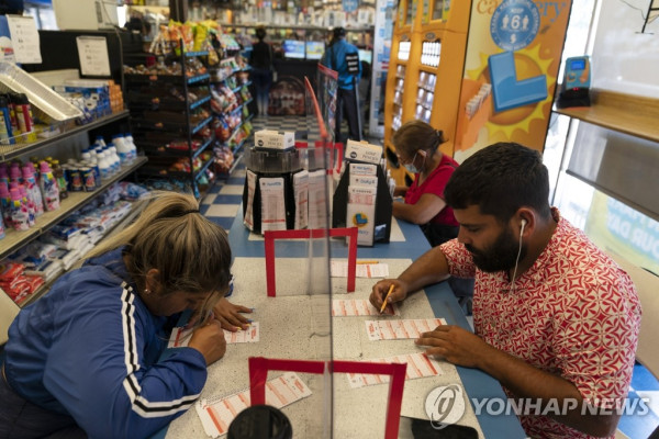 캘리포니아주 호손의 한 복권 판매점을 찾은 주민들이 메가 밀리언스 복권에 숫자를 기입하고 있다. (사진 출처=호손 AP / 연합뉴스)