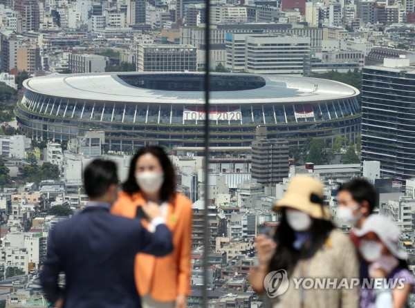 도쿄올림픽 개막식을 이틀 앞둔 21일 오후 일본 도쿄도(東京都)의 한 고층 건물 전망대 방문객들이 도심을 배경으로 기념사진을 찍고 있다.
