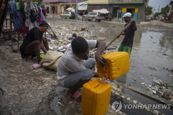 아이티 수도 포르토플랭스 시민들이 물을 담고 있는 모습