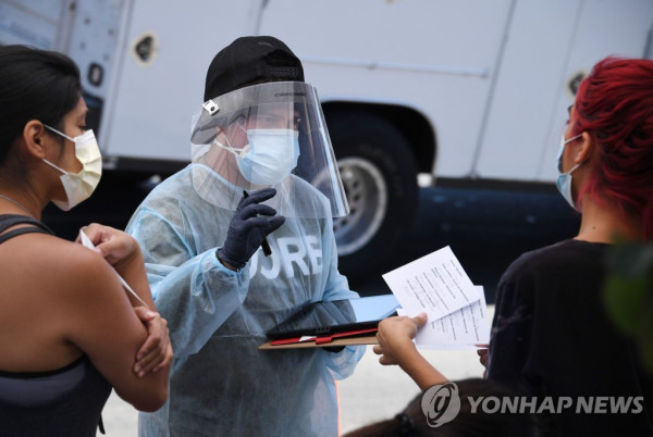 코로나19 검사를 받기 전 개인정보를 수집하기 위한 문서를 나눠주는 미국 의료진의 모습 [AFP=연합뉴스 자료사진]