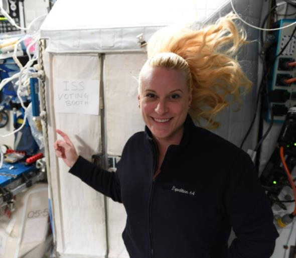 국제우주정거장 투표소 앞에서 포즈를 취한 우주비행사 케이트 루빈스
