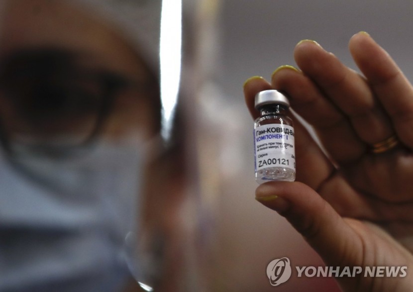 한 의료진이 러시아가 자체 개발한 코로나19 백신 스푸트니크V 병을 손에 들고 있다. [AP=연합뉴스]